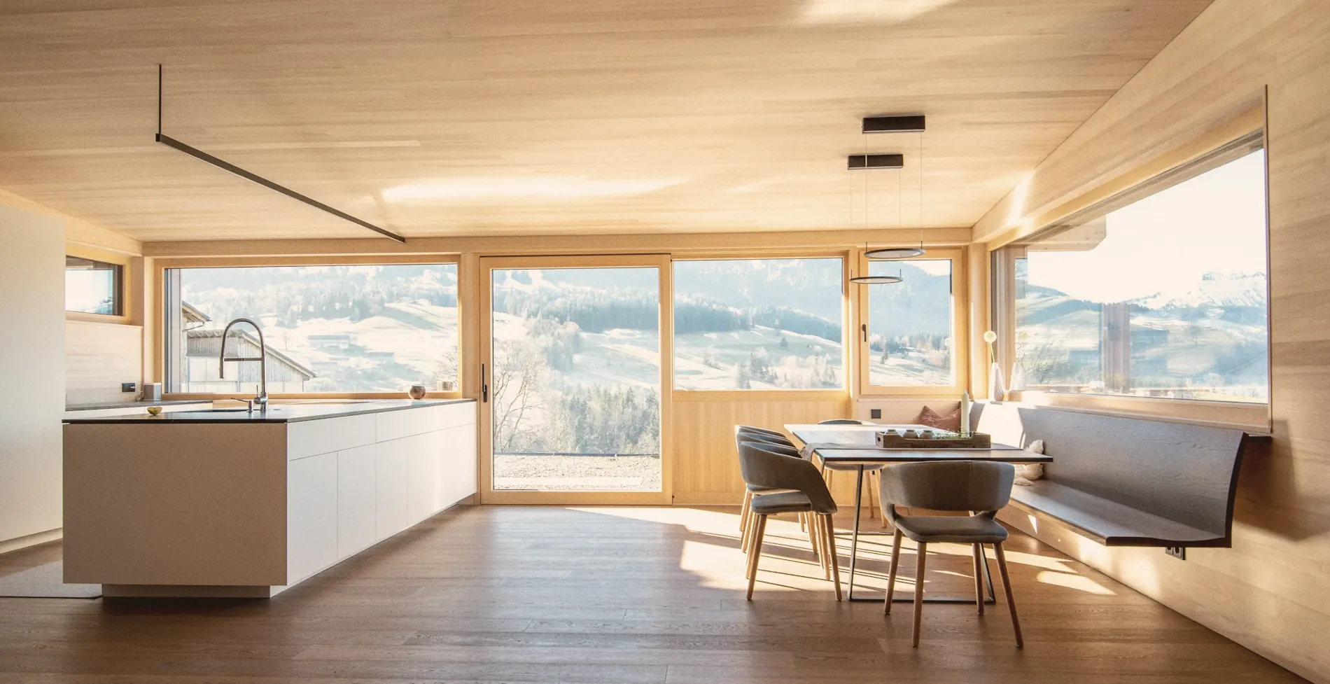 Warm timber home interior opening to a coastal view